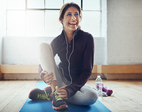 Shot of an attractive young woman listening to music while working out at home