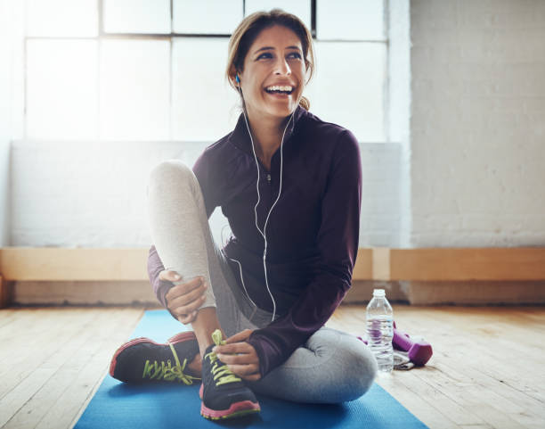 Exercising can leaving you feeling oh so great Shot of an attractive young woman listening to music while working out at home exercise mat photos stock pictures, royalty-free photos & images