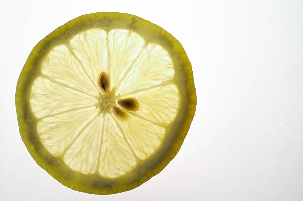 citron tranche gros plan sur une table légère (dos éclairés - fruit lightbox lemon portion photos et images de collection