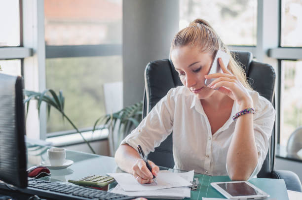 istock Girl in the office have mobile conversation and recording information. 910359934