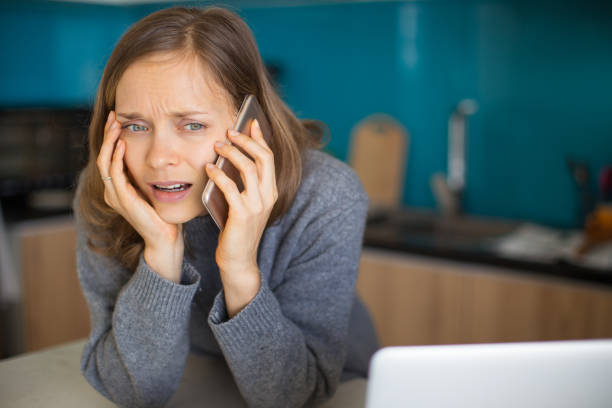 istock Worried Pretty Lady Talking on Phone in Kitchen 910363038