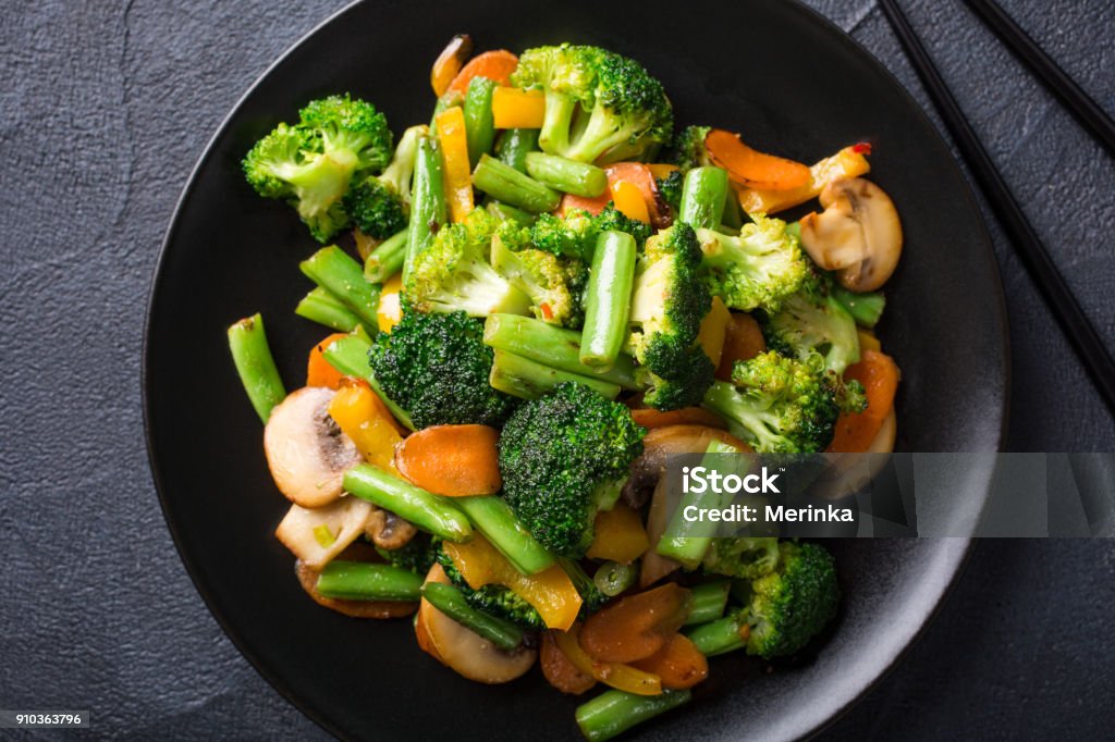 Stir fried vegetables Hot stir fried vegetables on black plate. Healthy asian food concept. Vegetable Stock Photo