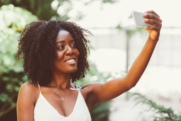 istock Smiling Black Lady Taking Selfie Photo in Park 910366472