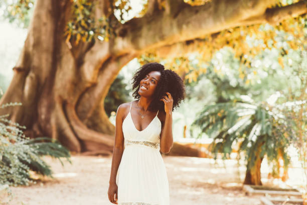 istock Smiling Dreamy Black Woman Walking in Park 910366486