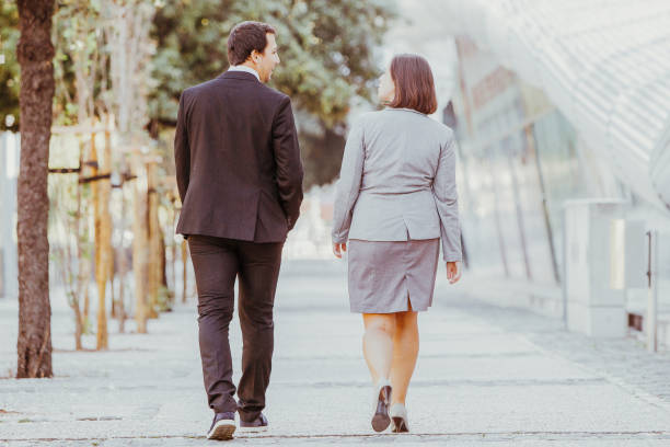 istock Back View of Two Partners Walking on Street 910366528