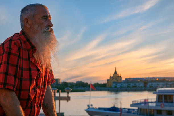 retrato senior hombre con barba blanca en un viaje a través de los ríos rusos, puesta de sol - oka river fotografías e imágenes de stock