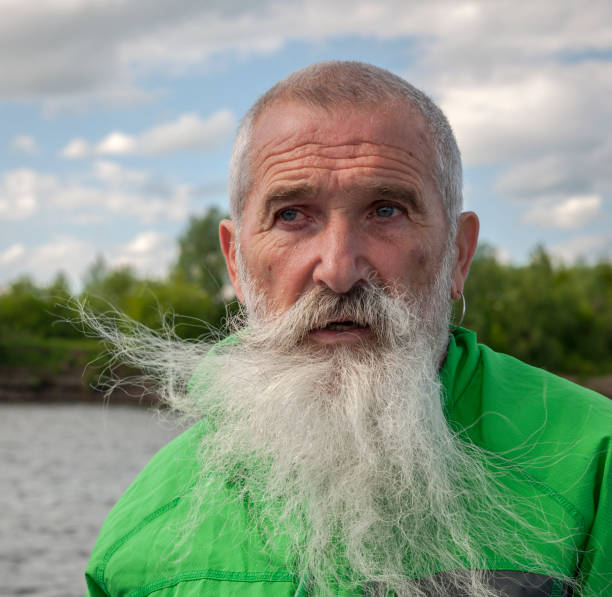 istock Portrait Senior Man with White Beard on a journey through the Russian rivers 910370624