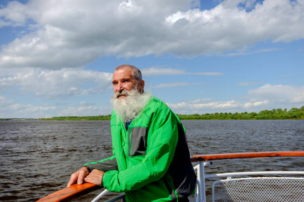 istock Portrait Senior Man with White Beard on a journey through the Russian rivers 910370632