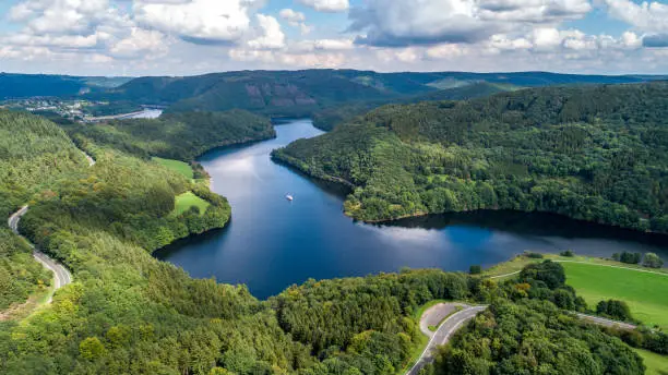 Bird's eye view over beautiful landscape with a lake and green forest from above taken by a drone