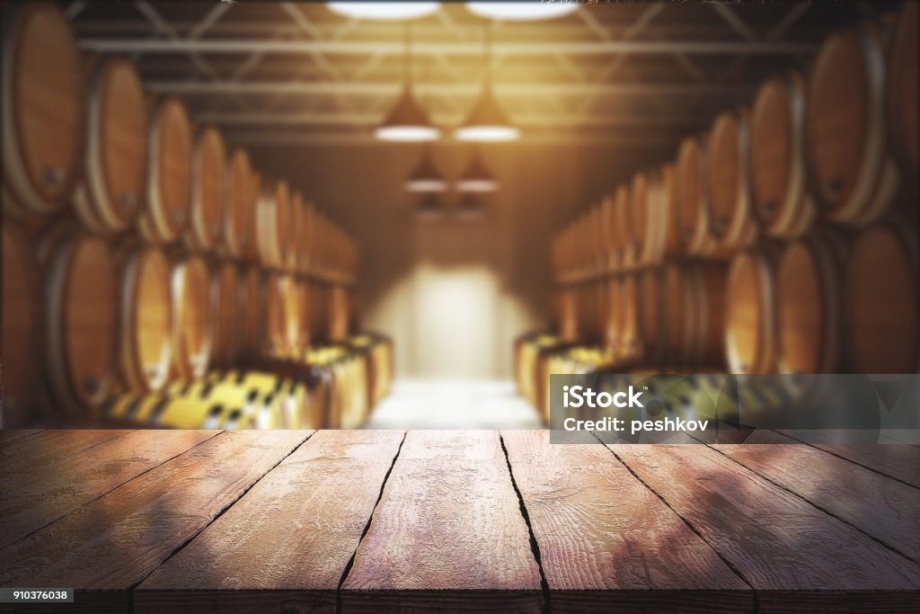 Winery and beverage concept Close up of empty wooden table with blurry wine barrels in the background. Winery and beverage concept. 3D Rendering Wine Stock Photo