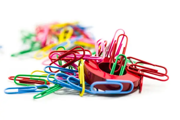 Photo of Magnet covered by paper clips isolated on a white background