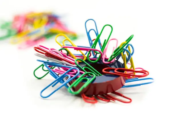 Photo of Magnet covered by paper clips isolated on a white background