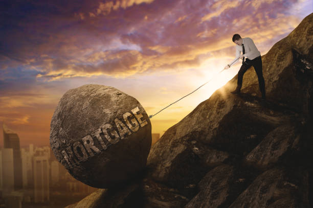 istock Male entrepreneur pull mortgage word on cliff 910407596