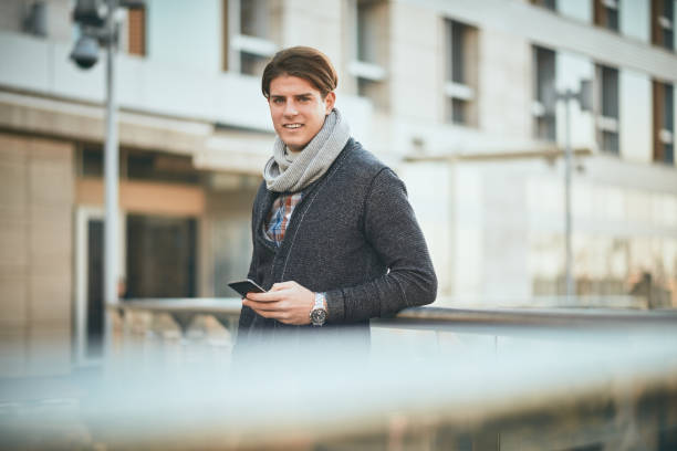 istock Man standing on the balcony and using smart phone. 910419150