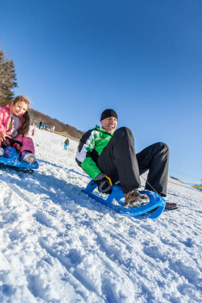 istock Father and Daughter tobogganing 910421936