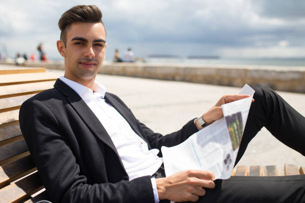 istock Confident young business analyst reading newspaper 910423604