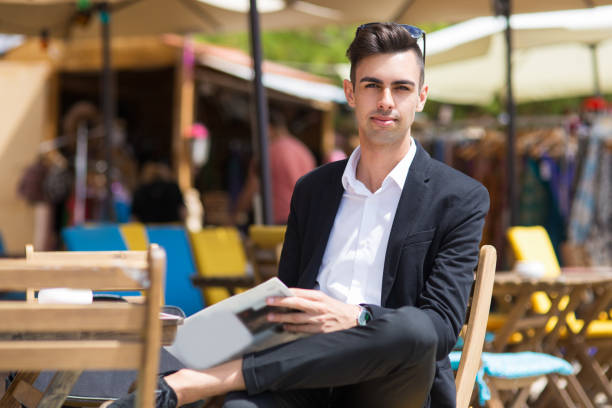 istock Serious handsome man resting in sidewalk cafe 910423656