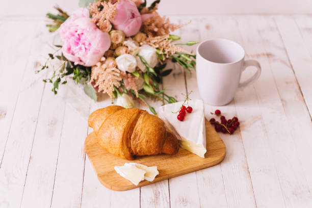 Croissant and cheese  on wooden cutting board
