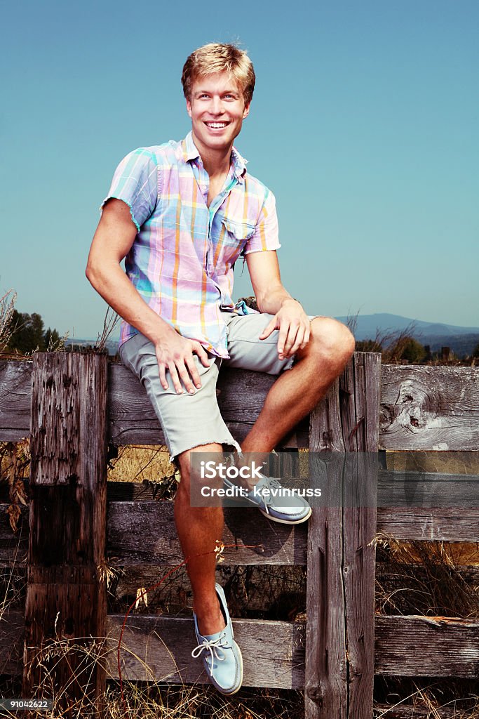 Ragazzo seduto sulla parete - Foto stock royalty-free di Abbigliamento casual