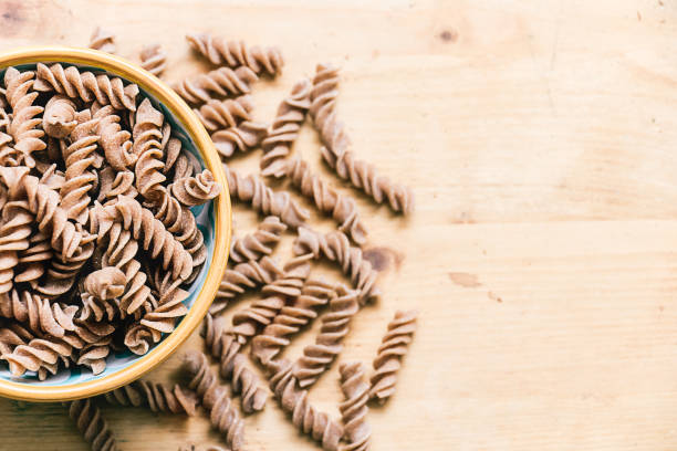 istock Ceramic dish filled with raw wholemeal fusilli pasta 910426962