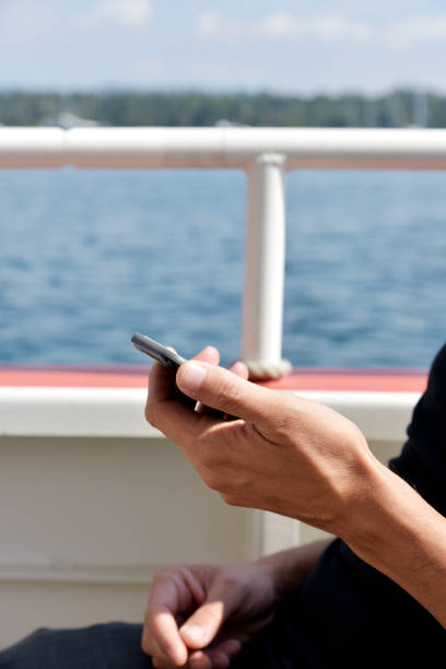 istock young man using a smartphone in the deck of a ship 910430138