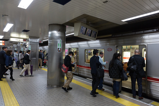 Osaka, Japan - April 8, 2015: Passengers at the Midosuji Subway Line Namba Station in Osaka, Japan. Osaka Municipal Subway’s Midosuji Line is an important rapid transit underground railway service running north-south in Osaka.