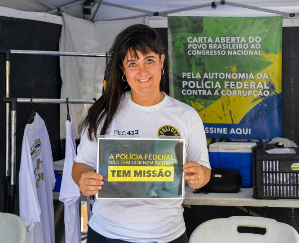федеральная бразильская женщина-полицейский, держащая табличку с надписью federal pol - minas gerais state flag brazilian flag brazil стоковые фото и изображения