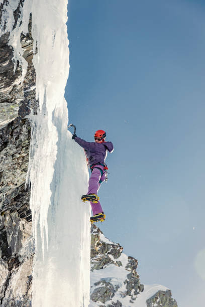 istock Woman ice climbing frozen waterfall 910439810