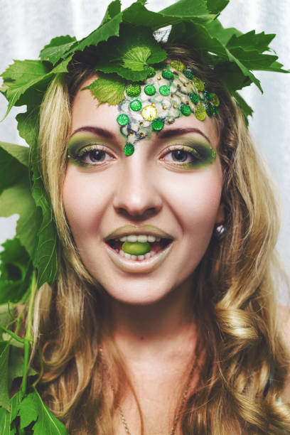 3d illustration of a beautiful woman with intricate gold eye makeup and an ornate headband looking forward and smiling on a white background.