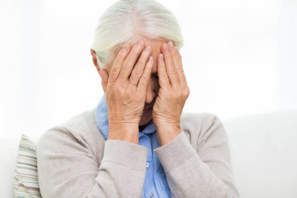 istock senior woman suffering from headache or grief 910453028