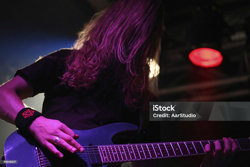 Guitarist Guitarist lit mostly by a purple reflector Amplifier Stock Photo