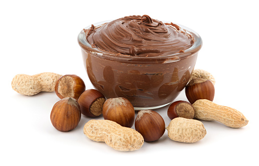 Delicious chocolate cream in a bowl and nuts isolated on white