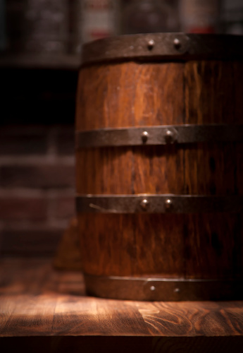 Barrel of whiskey on rustic table.blur bar background.Barrel of whiskey on rustic table.blur bar background.