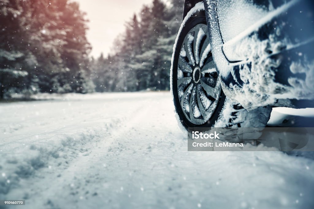 Car tires on winter road Car tires on winter road covered with snow. Vehicle on snowy way in the morning at snowfall Winter Stock Photo