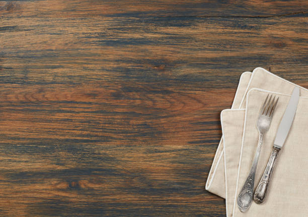 istock Knife, fork and towel on wood table 910468138