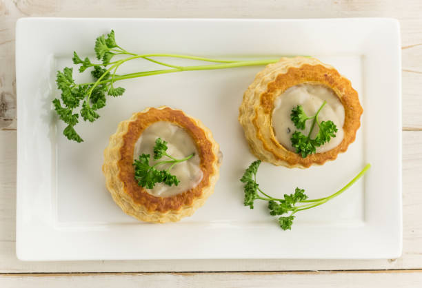 слоеное тесто vol-au-vents заполнено грибной тряпкой на белой тарелке - vol au vent стоковые фото и изображения