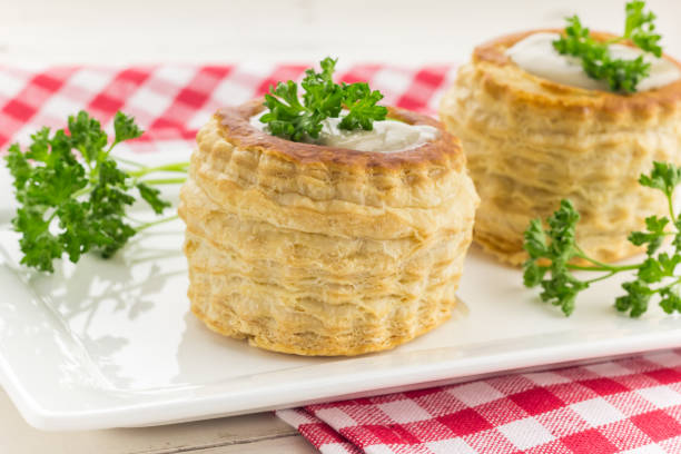 слоеное тесто vol-au-vents заполнено грибным рагу, увенчанным свежей петрушкой - vol au vent стоковые фото и изображения