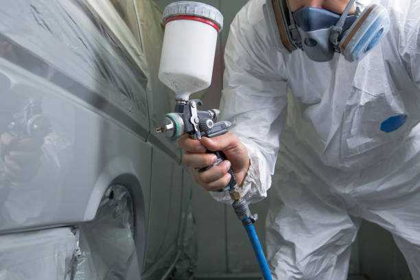 istock Painter spray gun in the hands of a painter. 910468646