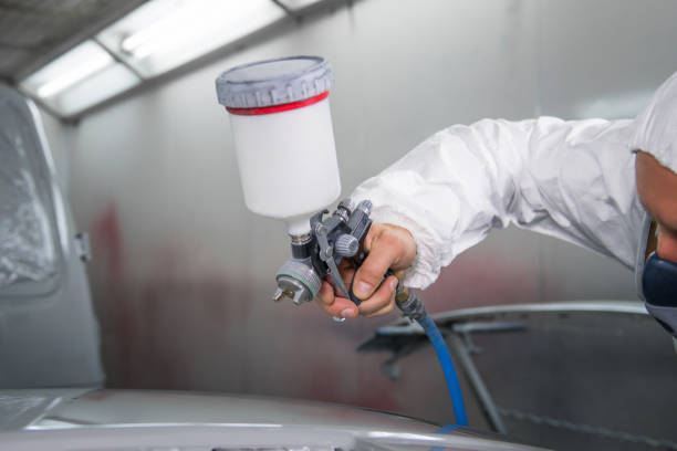 istock Painter spray gun in the hands of a painter. 910469048