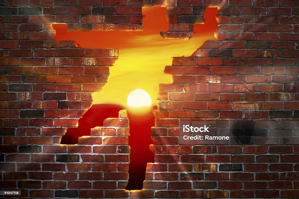 A person-shaped hole in a brick wall with the sun setting Brickwall that looks like someone ran though it exsposing a sunset. Hole Stock Photo