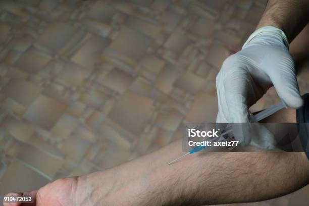 Injection Of A Medical Syringe Into His Hand A Medical Glove Stock Photo - Download Image Now