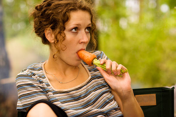 istock Young woman eating carrot 91047249