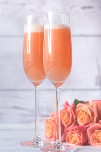 dois copos de cocktail bellini com buquê de rosas - champagne pink bubble valentines day - fotografias e filmes do acervo