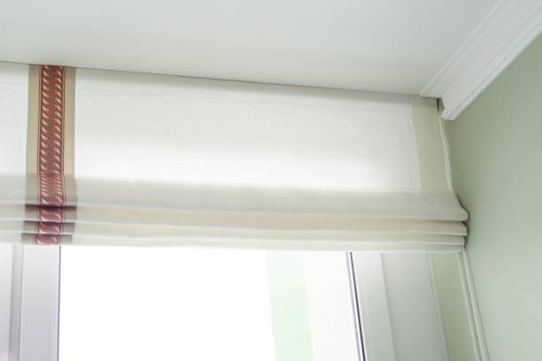 istock Roman curtains in the interior. From natural light linen, with decorative braid. 910484424