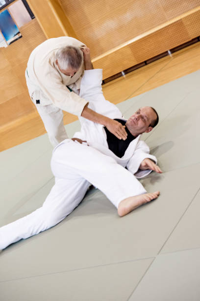 istock Senior Judo Fighter Holding Opponent to the Ground 910484578