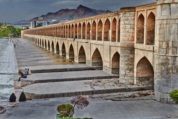 The illuminated Si-o-se-pol Bridge, also known as the Bridge of 33 Arches, crossing the Zayandeh River in Isfahan, Iran. Built during the Safavid dynasty in the early 17th century, this iconic structure is one of the most famous examples of Persian bridge architecture.