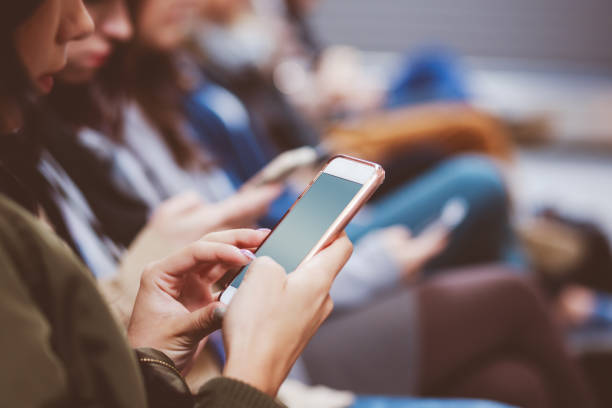 istock Young woman using smart phone while waiting for flight in airport lounge 910489230