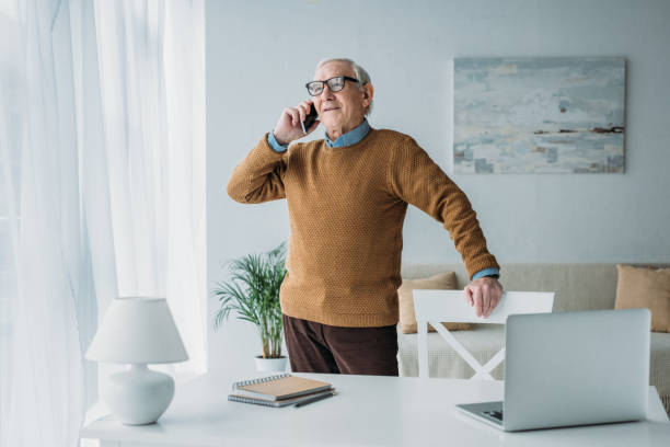 istock Senior confident man working in office and making phone call 910492028