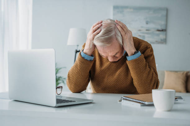 istock Senior man working in office and suffering from headache 910492624