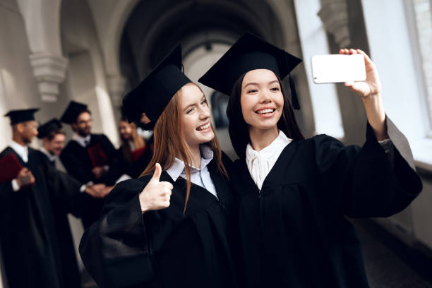 istock Two girls in black mantles are making selfie. 910493600